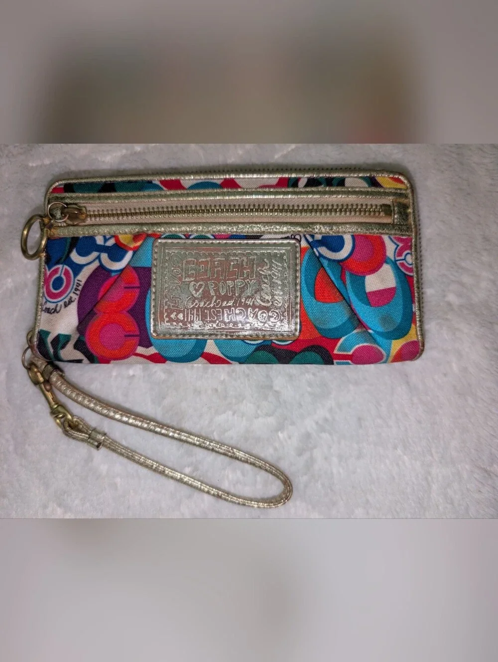 Coach Poppy graffiti print zip-around wristlet with a gold leather wrist strap